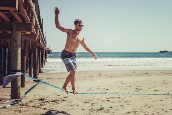 Man Standing on Rope Near Beach