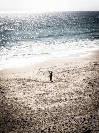 man standing on sand near shore