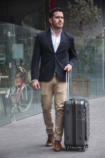Man Standing On Sidewalk While Holding Luggage Bag