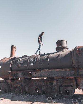 Man Standing on top of Abandoned Train