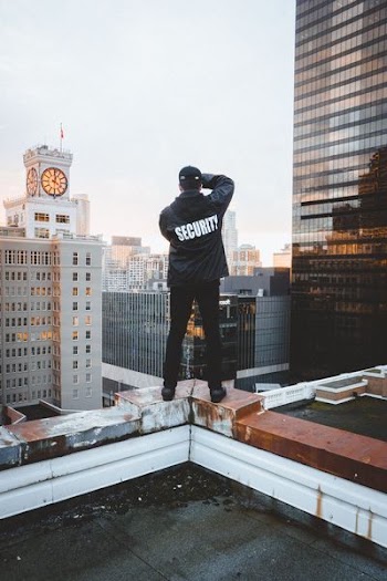 man standing on top of building under white sky during daytime