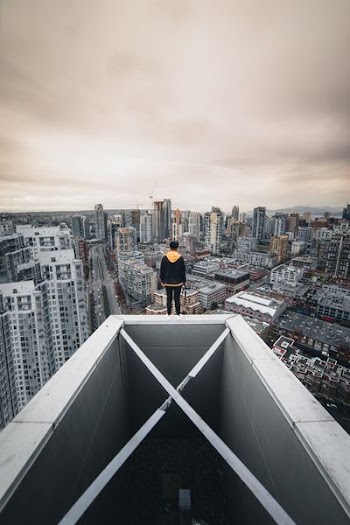 man standing on top of high-rise building