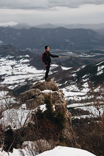 Man Standing on Top of Mountain