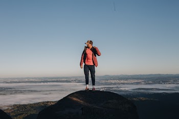 Man Standing on Top of Rock