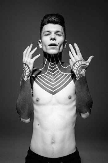man standing showing black tattoo