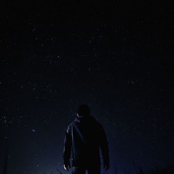 man standing under milky way