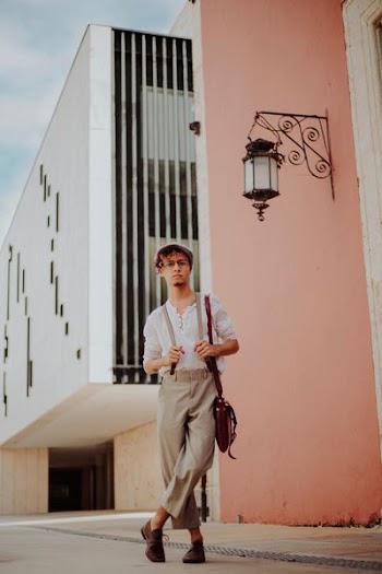 man standing while holding his suspenders