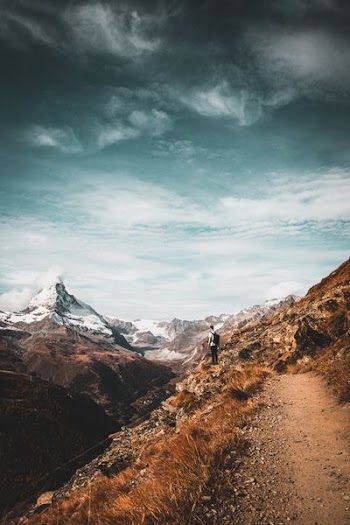 man standing while looking at mountain range