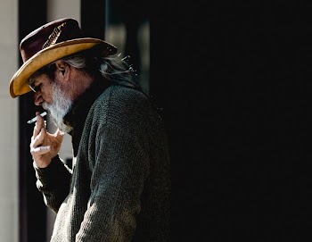 man standing while smoking cigarette