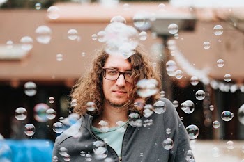 man standing while surrounded by bubbles