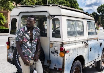 Man Stands Near White Land Rover Defender at Daytime