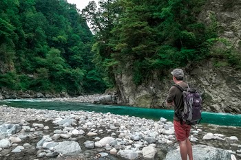Man Staring at Flow of Water Outdoors