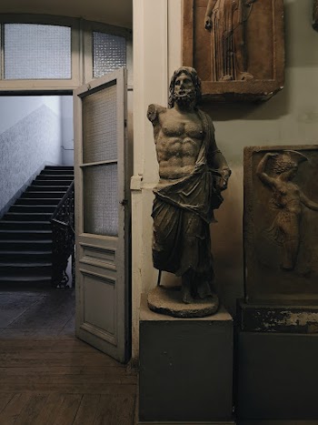 Man Statue Beside Embossed Portraits
