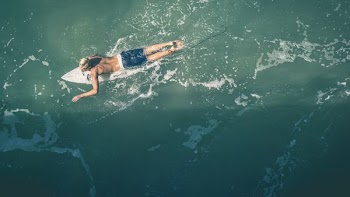 man surfing using white surfboard during daytime