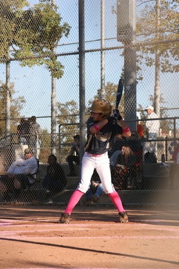 Man Swinging Bat Near Gray Fence Outdoors