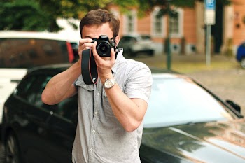 Man Taking a Picture Beside the Car