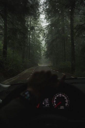 man taking photo of road while driving car