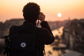 man taking photo of sunset