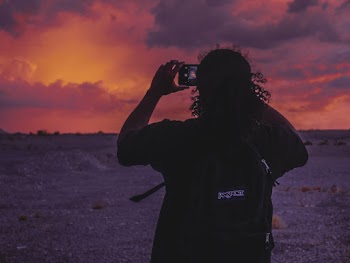 Man Taking Photo Of Sunset