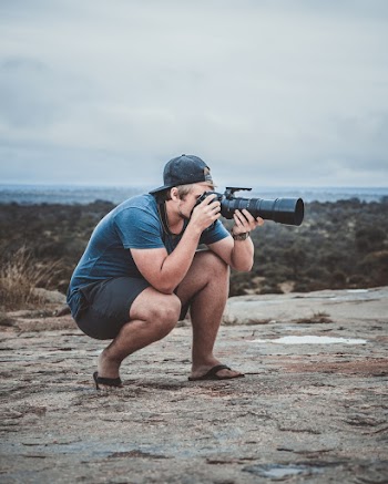Man Taking Photo Using Black Dslr Camera