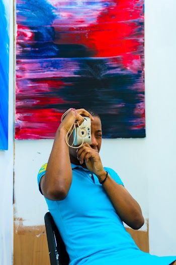 Man Taking Photo While Sitting on Black Chair
