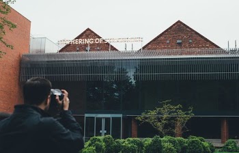 man taking picture to building