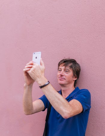 Man Taking Selfie While Leaning on Wall