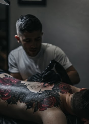 Man Tattooing Person's Back