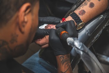 Man Tattooing Wrist Of Another Person