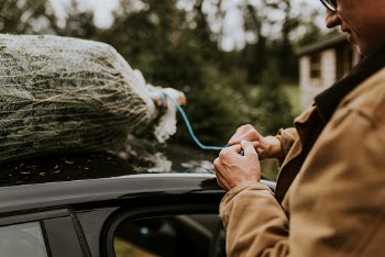 Man tying his Christmas tree | Free Photo - rawpixel
