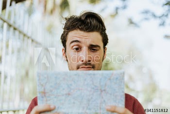 Man using a map in downtown park