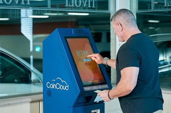 Man Using CoinCloud Digital Kiosk for Cash-to-Crypto Transactions
