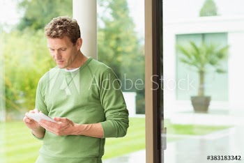 Man using digital tablet in window
