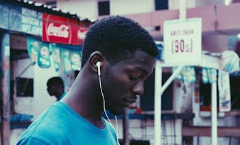 Man Using Earphones Near Store