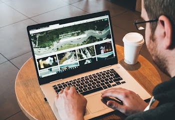 Man Using Laptop on the Table With Cup of Hot Beverage