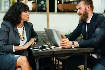 man using laptop sitting in front of woman
