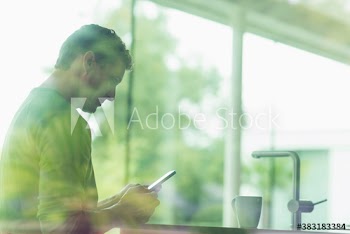 Man using smart phone in kitchen