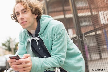 Man using smart phone on city sidewalk
