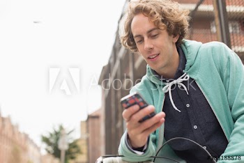 Man using smart phone on city street
