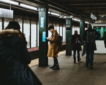 man using smartphone inside the train station