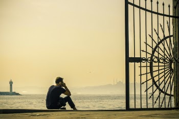 Man Using Smartphone While Sitting by the Beach