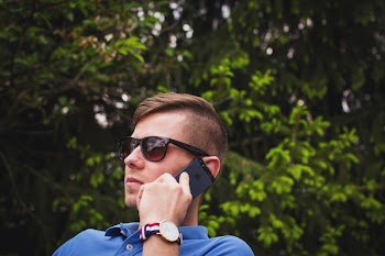 Man Using Using Smartphone Near Green Leafed Trees