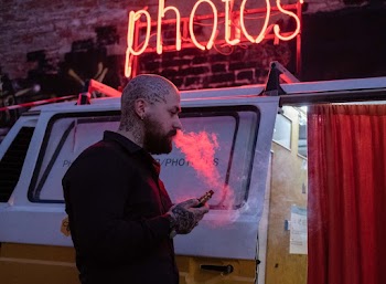 Man Vaping Beside White Van