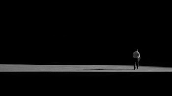 Man Walking Away In Shadows