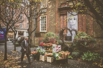 man walking beside flowershop