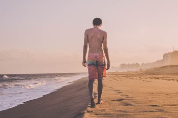 man walking beside sea shore