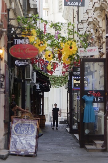 Man Walking Between the Alley