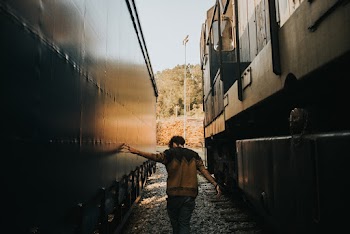Man Walking in Between Trains