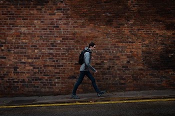 man walking in sidewalk