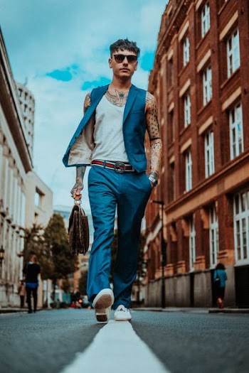 man walking in the middle of the road during daytime